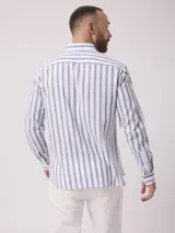 Camisa de manga larga a rayas verticales azules y blancas, con cuello abotonado y bolsillo en el pecho. Confeccionada en lino y algodón.