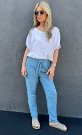 Pantalón celeste jean estilo babucha, de algodón tramado, con cintura elastizada y cordón ajustable.