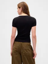 Remera de manga corta ajustada al cuerpo, color gris claro, con tejido acanalado (rib). Presenta un escote redondo amplio.