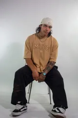 Remera color arena con cuello redondo y estampado frontal con letras "MTPE" en marrón.