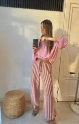 Pantalón de punto marrón con rayas verticales rosas, corte palazzo y cintura con cordón ajustable.