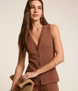 Blusa estilo chaleco color marrón, confeccionada en ribana, con abotonado delantero, sin mangas y con textura acanalada.