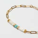 Pulsera dorada con cadena de eslabones y detalle central de cuentas rectangulares blancas y turquesas.