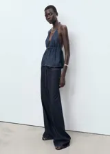 Pantalón de jean wideleg de tiro bajo con cierre de botón y cremallera, cinco bolsillos y diseño largo.