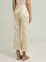 Pantalón negro con estampado dorado de motivos geométricos, corte flare y tiro alto.