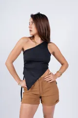 Top blanco de un solo hombro con corte asimétrico y cordón ajustable en el lateral.