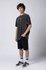 Remera negra con efecto gastado, corte holgado y estampa frontal con la frase 'Astral Energy' en blanco.