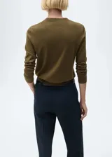 Jersey de punto fino color crudo, con cuello redondo y mangas largas.