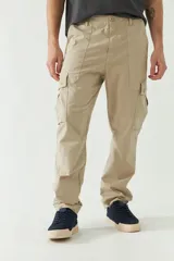 Pantalón cargo color beige para hombre, de corte recto, con bolsillos laterales y traseros. Se ajusta a la cintura con cinturón de cuero marrón.