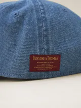 Gorra de béisbol negra de gabardina con visera curva y etiqueta con logo en la parte trasera.