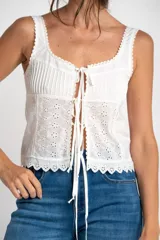 Musculosa blanca de algodón con bordado calado, alforzas y terminaciones de puntilla.