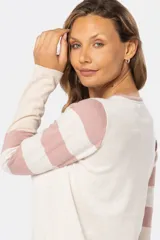 Buzo de tejido fino con diseño de bloques de color en beige, rosado y azul, y mangas con rayas horizontales en beige y rosado. Confeccionado en algodón, de manga larga y cuello redondo.