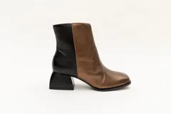 Botas cortas de cuero plateado y negro con punta cuadrada y taco geométrico.