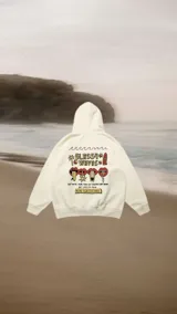 Hoodie color crema con capucha y cordón ajustable. Estampado en la espalda con motivos playeros y texto en negro.