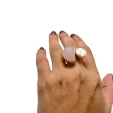 Anillo artesanal con base de bronce bañada en oro, con cuarzo rosa en forma de media luna y perla barroca. Talla ajustable.