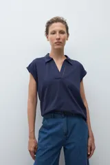 Remera de manga corta color rosa pálido, con cuello polo y escote en V con detalle de bordado en el borde.