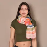Pashmina rectangular de poliéster con estampado tie-dye multicolor en tonos naranja, verde, gris y rosa.