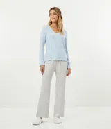 Conjunto de pijama largo de dos piezas en tejido de punto suave. La blusa es de manga larga con cuello en V y detalle de encaje. El pantalón es de corte recto con cintura elástica.