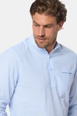 Camisa de lino color beige, de manga larga, cuello mao, medio abotonada y corte slim.