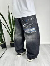 Pantalón baggy de denim negro con efecto lavado y estampados con tipografías y logos en blanco y azul.