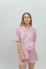 Conjunto de pijama de algodón a rayas verticales rosas y blancas, con detalles en celeste. Incluye camisa de manga corta con botones y bolsillo en el pecho, y shorts con cintura elástica.