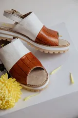 Sandalias de cuero con plataforma, color marrón con detalle de estampado tipo piel de cocodrilo en la parte delantera y blanco en la parte trasera.