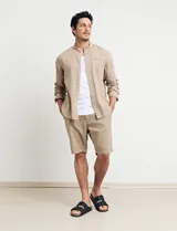 Camisa de lino color beige, de cuello mao y manga larga.