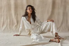 Camisa de manga larga color crema con estampado floral en relieve, cuello clásico y cierre frontal con botones.