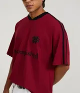 Remera deportiva masculina oversized color gris oscuro con cuello en V blanco, mangas cortas con rayas blancas, estampa localizada y lettering blanco.