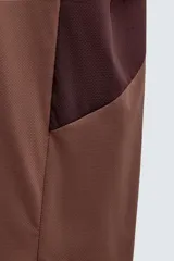 Camiseta marrón con paneles laterales en marrón oscuro, corte relaxed fit, cuello redondo y manga corta.