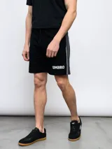 Bermuda deportiva negra de piqué con cordón ajustable en la cintura, logo Umbro estampado en blanco y detalle de ribete gris en los laterales.