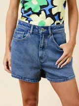 Short de jean azul de tiro alto, corte slim fit y ruedo desflecado.