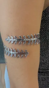 Brazalete plateado con diseño de hojas.