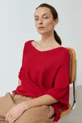 Sweater de tejido de punto color rojo vibrante, con escote en V amplio y mangas cortas tipo murciélago, de calce holgado.