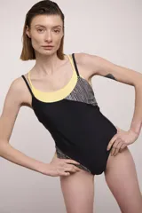 Malla entera negra con escote redondo, breteles finos negros y espalda baja. Presenta un panel superior con estampado de rayas verticales blancas y negras, y un panel amarillo en el escote.