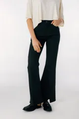 Pantalón de jean azul de corte acampanado con aberturas en el ruedo.