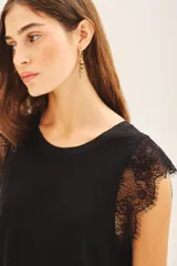 Musculosa blanca de lino con detalle de encaje en mangas y cuello. Tiene bordado de alas en el bajo.