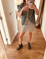 Minifalda tejida en lurex plateado, con flecos en el ruedo y cintura elástica.