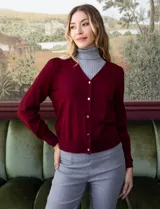 Cardigan de hilado fino color azul, con escote en V y apertura central con botones metálicos.