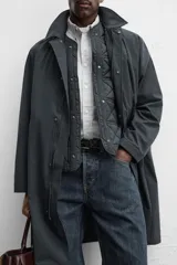 Parka relaxed fit confeccionada en tejido técnico repelente al agua. Interior acolchado desmontable. Cuello solapa con capucha desmontable. Manga larga con puño ajustable con botones a presión. Bolsillos de vivo en cadera. Bajo con abertura central en espalda. Cierre frontal con cremallera oculta por solapa con botones a presión. Chaleco interior acolchado y desmontable con cuello pico y manga sisa.