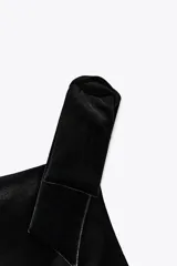 Vestido corto negro de terciopelo, con escote cuadrado y tirantes gruesos con detalle de lazos.