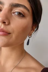 Aros colgantes de acero quirúrgico hipoalergénico con dije de piedra natural en forma de gota color azul oscuro.