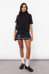 Remera negra de jersey con cuello alto, corte boxy fit y mangas cortas. Estampa transparente centrada en la espalda.