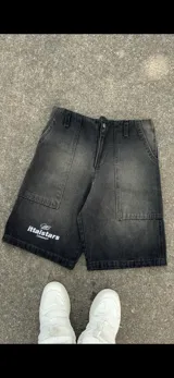 Short de jean negro con efecto lavado, corte a la rodilla y estampado con el logo de la marca en blanco en la pierna izquierda.