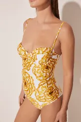 Traje de baño enterizo blanco con estampado de flores amarillas, con breteles finos y copas con aro.