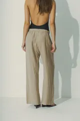 Pantalón de lino color beige, de corte palazzo con cintura elastizada.