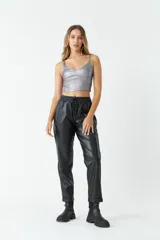 Pantalón negro de cuero sintético, tiro medio, con cintura ajustable, bolsillos laterales y corte holgado.