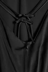 Vestido largo negro de seda, con escote en V pronunciado y tirantes finos que se unen en la espalda con un diseño halter.