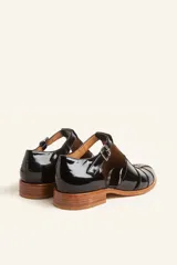 Sandalias de cuero color marrón claro, con diseño de tiras entrecruzadas y hebilla lateral.