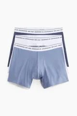 Pack de tres calzoncillos tipo trunk en azul, blanco y azul marino, con cintura elástica blanca con la inscripción "Designed in Stockholm Est. 1947". Confeccionados en tejido funcional COOLMAX® y Lycra® Xtra Life™.